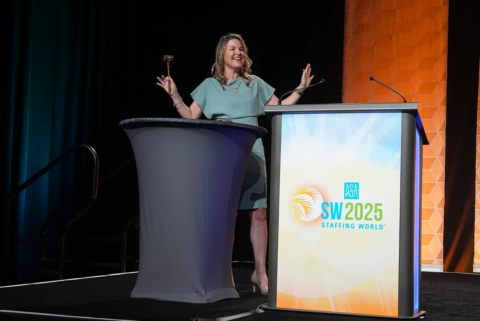 A speaker on the Staffing World 2025 stage beside the event-branded lectern