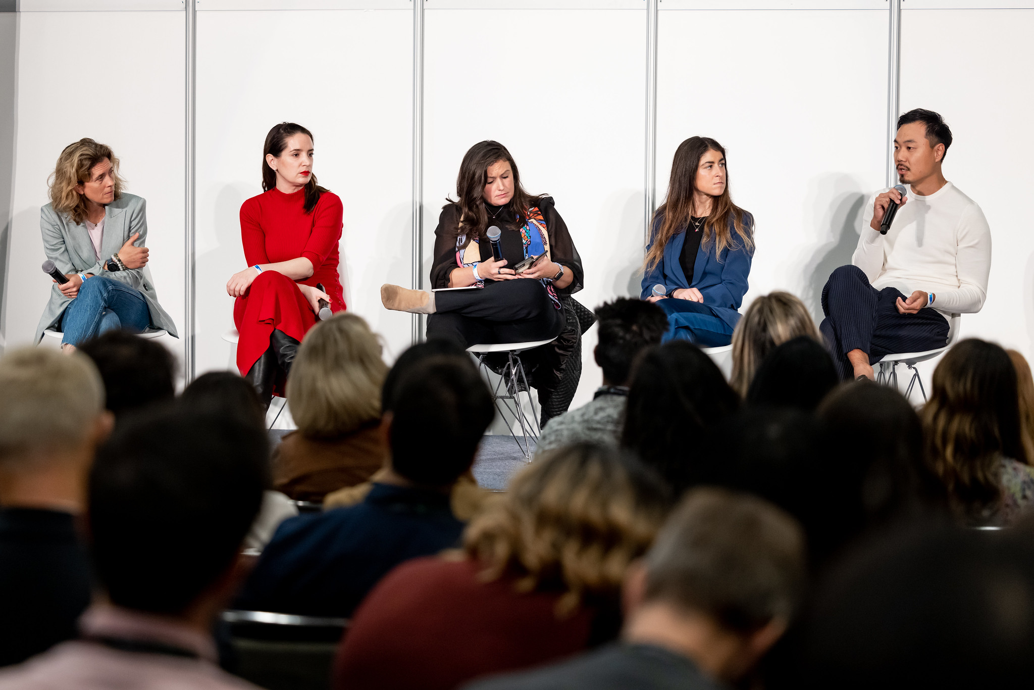 Five speakers on a technology conference panel in front of a seated audience